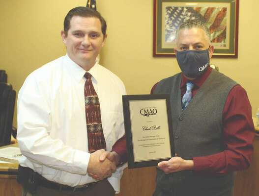 Dave Slezickey (right), president of City Managers Association of Oklahoma (CMAO) presents a plaque to city manager Chuck Ralls in recognition of Ralls completing the course work to become an accredited manager of the CMAO. The presentation was made at the city council meeting last Tuesday. Slezickey praised Ralls’ work in the program.